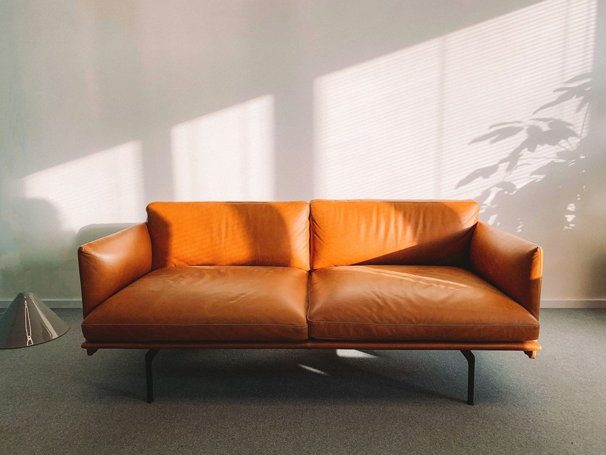Tan two-seat sofa with slim black legs